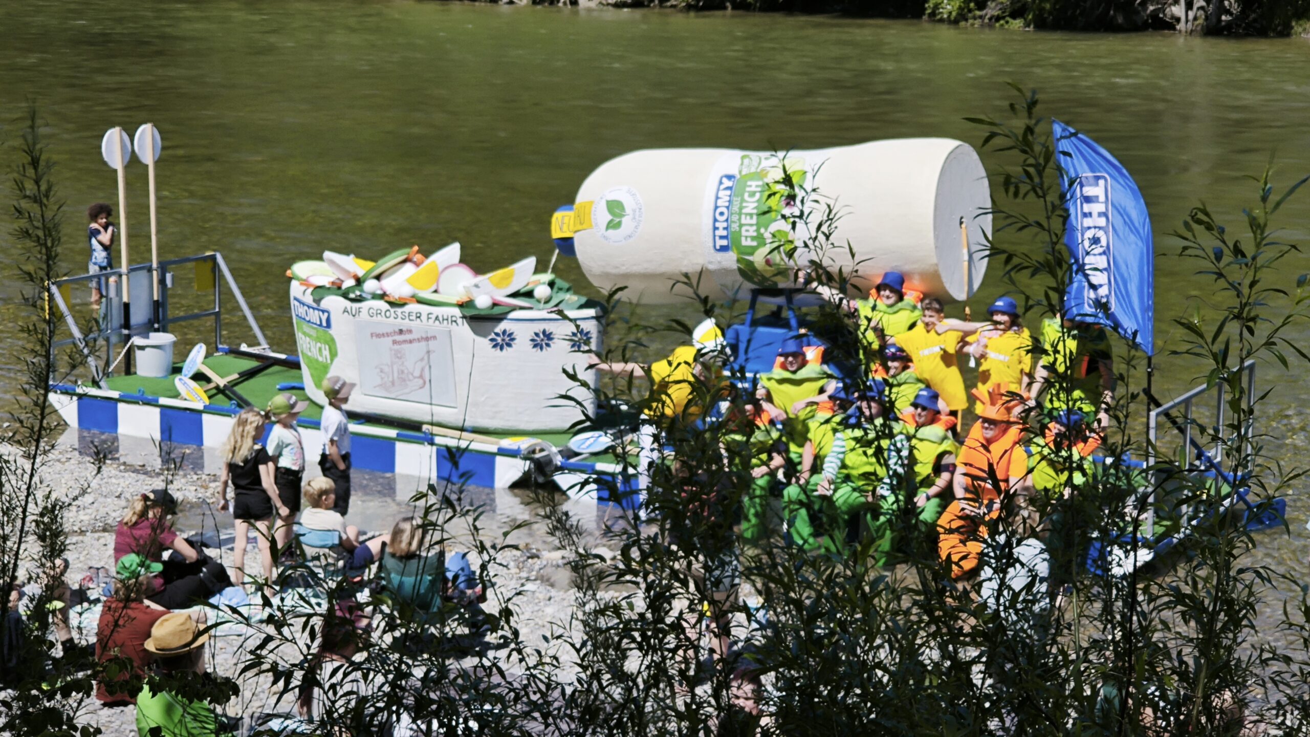 Die Crew posiert auf dem Floss am Ufer der Thur